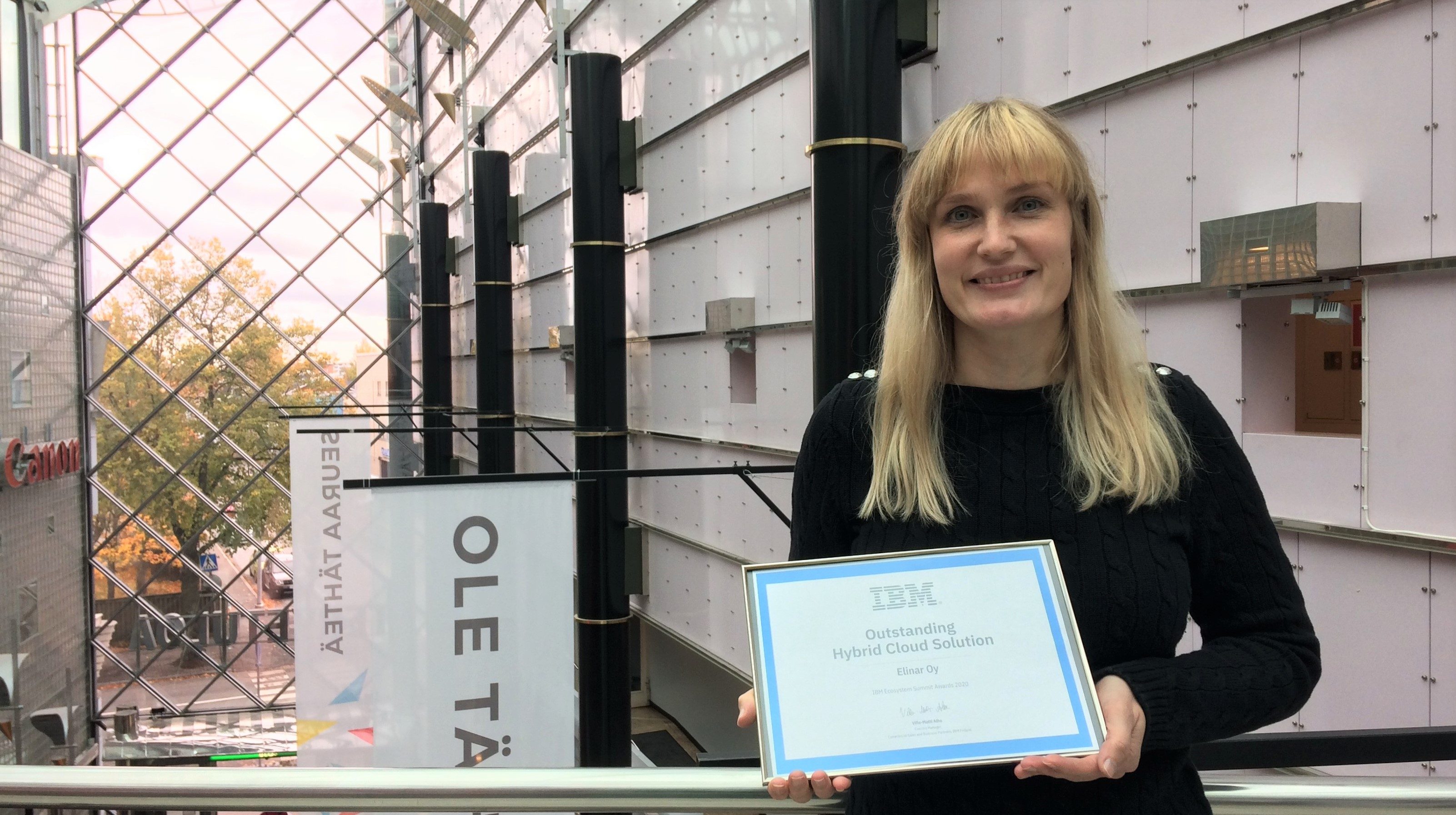 Leena Tähti holds an award for Elinar's AI integration with IBM's technology